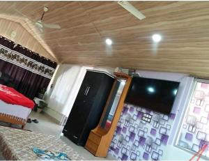 a room with a tv and a bed and a room at Rahul Residency Homestay- Couple & Family friendly- 'prime location- Easy access to Mall Rd- WiFi- Smart TV - Kitchen- City view in Solan