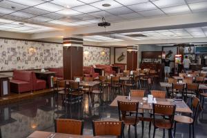 a restaurant with tables and chairs in a room at Alpen Ville in Almaty