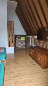 a living room with a tv and a wooden floor at Qinoz Villaz in Kedungwaru