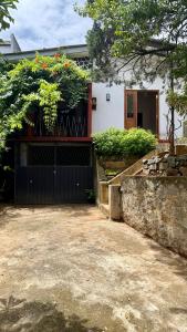 a house with a black gate in front of it at Alex s Cottage in Kandy