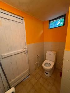a bathroom with a toilet and a window at Alex s Cottage in Kandy +2 photos