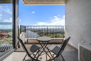 a table and two chairs on a balcony with a view at Chic 1-Bed with Stunning Lake View & Indoor Pool in Belconnen