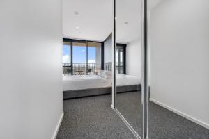 a bedroom with a bed and a large mirror at Chic 1-Bed with Stunning Lake View & Indoor Pool in Belconnen