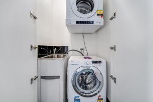 a washing machine and a sink in a room at Chic 1-Bed with Stunning Lake View & Indoor Pool in Belconnen +3 photos