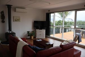 a living room with a couch and a large window at Serenity House in Mallacoota
