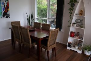a dining room table with chairs and a window at Serenity House in Mallacoota +15 photos