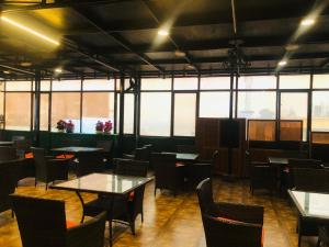 a dining room with tables and chairs and windows at Peace Continental Hotel in Islamabad