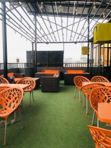 a room with orange chairs and tables on a ship at Peace Continental Hotel in Islamabad