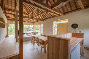 a kitchen and dining room with a table and chairs at 比地の宿 in Kunigami