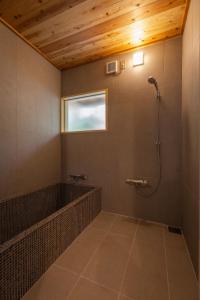 a bathroom with a shower and a window at 比地の宿 in Kunigami