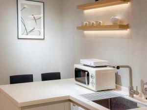 a microwave sitting on a counter in a kitchen at Euljiro Central 3BR Stay in Seoul