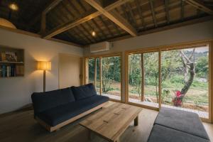 a living room with a blue couch and a wooden table at 比地の宿 in Kunigami