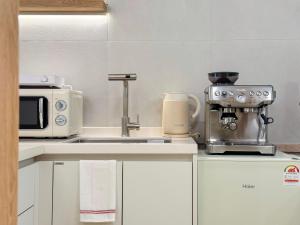 a kitchen with a microwave and a coffee maker at Euljiro Central 3BR Stay in Seoul