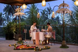 a man and woman sitting at a table with candles at Kahayana Suites Ubud in Ubud +42 photos