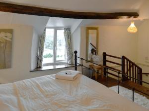 a bedroom with a white bed with a window at Crogen Bryn Awel in Llandrillo