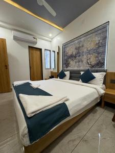 a bedroom with a large bed with blue pillows at The Premier, Dwarka in Dwarka