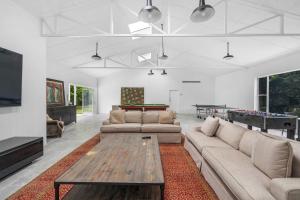 a living room with couches and a pool table at Grovebrook Cottage, Broughton in Woodhill
