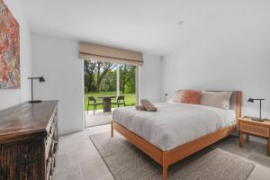 a bedroom with a bed and a table and a window at Grovebrook Cottage, Broughton in Woodhill