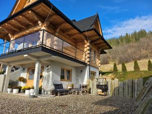 a house with a wooden roof with a balcony at Osada Poronin in Poronin