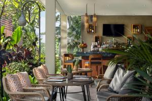 a patio with tables and chairs and a bar at Kahayana Suites Ubud in Ubud