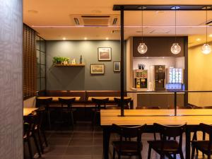 a dining room with wooden tables and chairs at Super Hotel Tottori Station North Exit Smoke-Free in Tottori