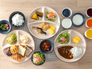 a table with four plates of food on it at Super Hotel Tottori Station North Exit Smoke-Free in Tottori