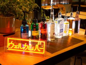 a lit up sign on a table with bottles of alcohol at Super Hotel Tottori Station North Exit Smoke-Free in Tottori