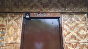 a door to a building with a sign above it at Nipaville Haven in Moalboal