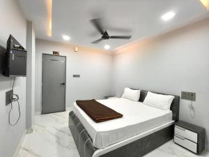 a bedroom with a bed and a flat screen tv at Hotel Rudra in Wākal +9 photos