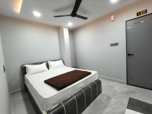 a bedroom with a bed and a ceiling fan at Hotel Rudra in Wākal