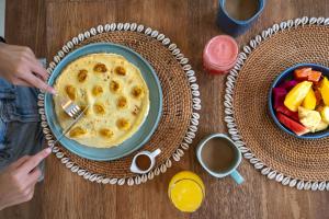 a table with a bowl of fruit and a plate of food at Fraser Baye Villas in Uluwatu