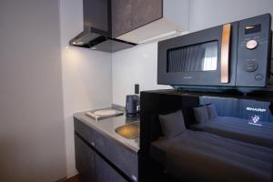 a small kitchen with a microwave and a sink at Hotel FUK O in Fukuoka