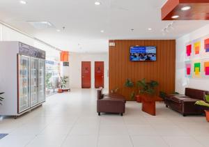 a lobby with couches and a tv on the wall at Cris Inn Tagum in Tagum