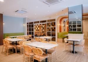 a restaurant with tables and chairs in a room at Cris Inn Tagum in Tagum