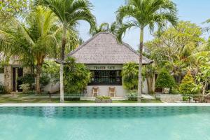 a resort with a swimming pool in front of a building at Fraser Baye Villas in Uluwatu +34 photos