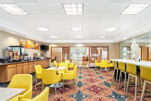a dining room with yellow chairs and tables at Comfort Suites Clackamas in Clackamas