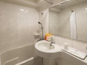 a white bathroom with a sink and a bath tub at Comfort Hotel Suzuka in Suzuka +22 photos