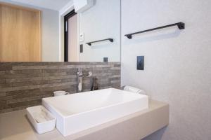 a bathroom with a white sink and a mirror at Hotel FUK O in Fukuoka +31 photos