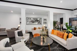 a living room with white furniture and orange pillows at CH Boutique Hotel, an Ascend Collection Hotel in Tamworth