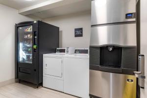 a kitchen with a refrigerator freezer next to a counter at Comfort Inn & Suites Tigard near Washington Square in Tigard