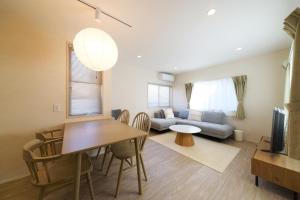 a living room with a table and a couch at JAPANDI HOTEL Nagoya in Chikusachō