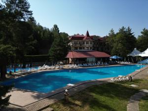 a large swimming pool in front of a hotel at Olympica Hotel in Almaty