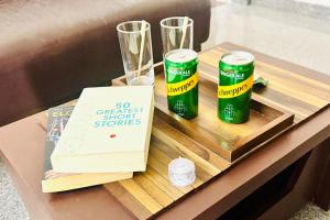 a table with two green cans on a wooden tray at Visaara Luxury Homes in Kammasandra
