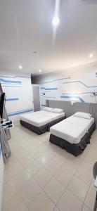 a room with two beds in a room at One Stop Hotel Ipoh in Ipoh