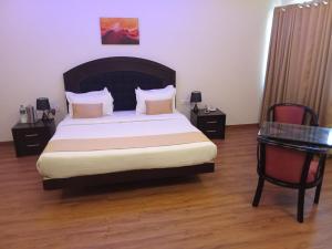a bedroom with a large bed and a table at Hotel Gentleman Mithila in Eramalloor