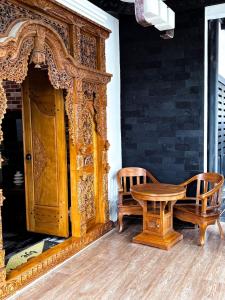 a wooden table and two chairs next to a wooden door at Bints Guesthouse Syariah in Banjarbaru