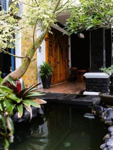a house with a koi pond in the yard at Bints Guesthouse Syariah in Banjarbaru