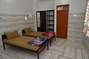 a room with two beds and a door at Sarvjanik Hindu Dharamshala in Nīmri