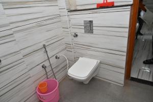 a small bathroom with a toilet and a bucket at Sarvjanik Hindu Dharamshala in Nīmri