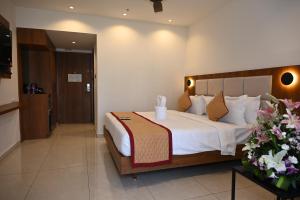 a bedroom with a large bed in a hotel room at Good One Suites Near Manyata Tech Park in Bangalore